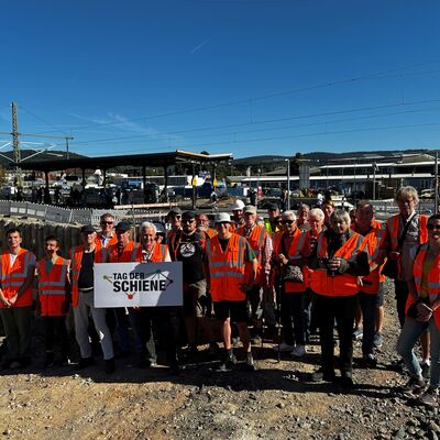 Gruppenfoto vom Tag der Schiene mit Bahnhof im Hintergrund