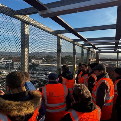 Eine Besuchergruppe auf einer temporären Brücke