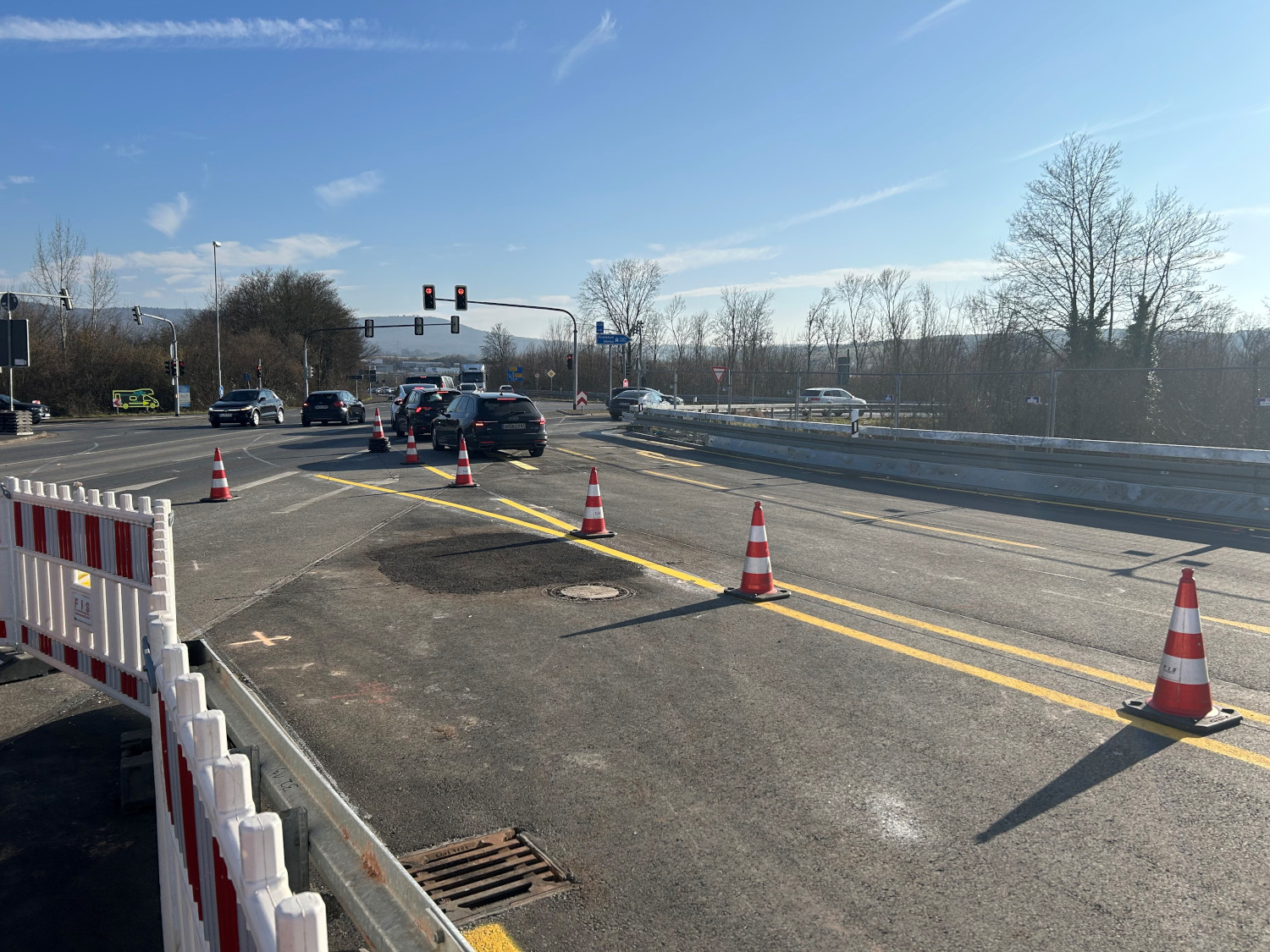 Autos auf der Hilfsbrücke mit gelben Fahrbahnmarkierungen und rot-weißen Pylonen
