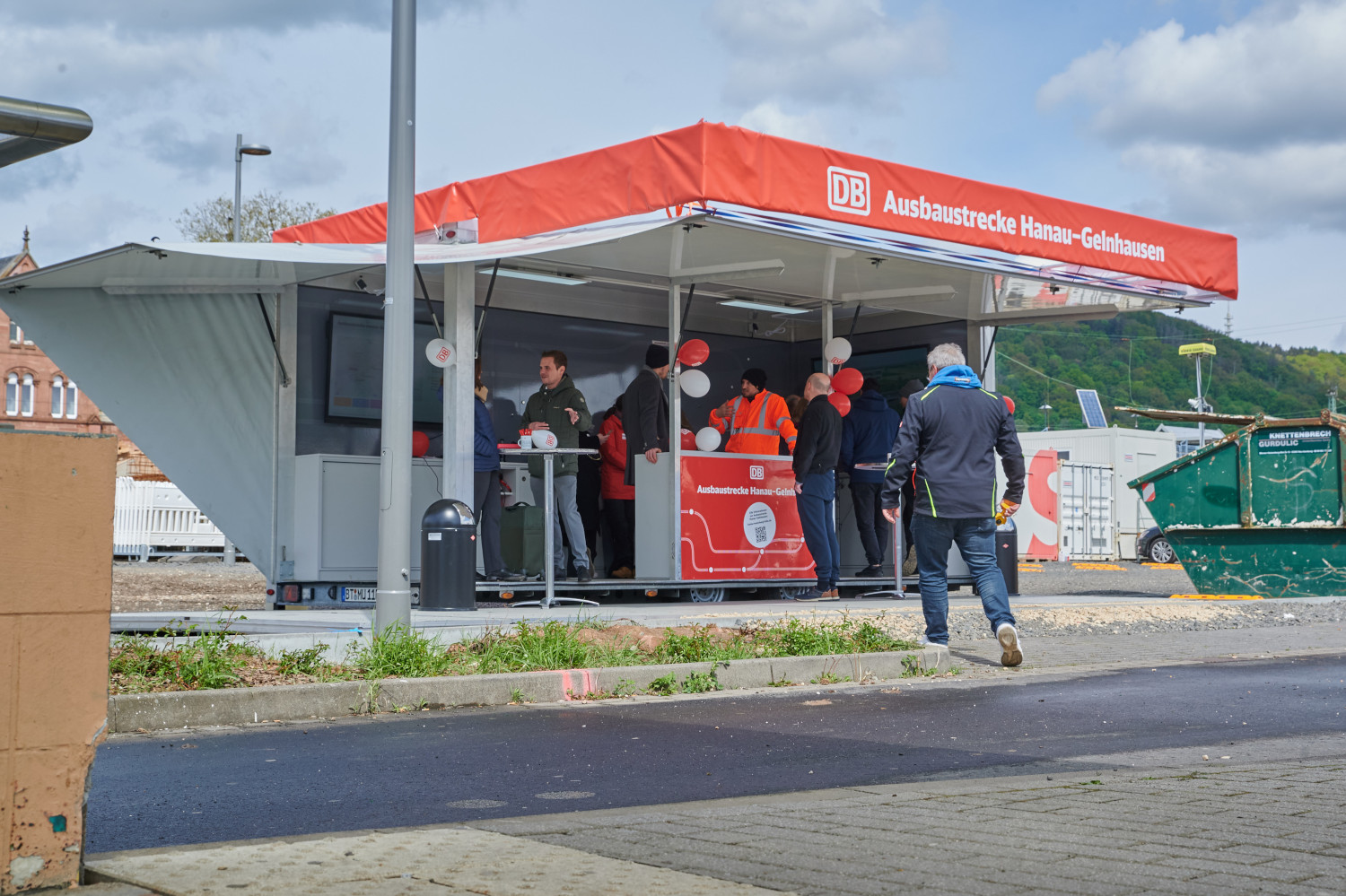 Bahnmitarbeitende im Gespräch mit Besuchern am Infomobil